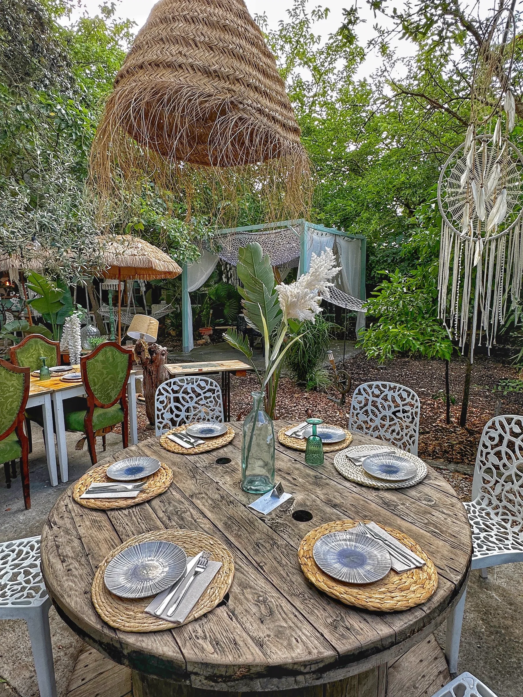 Mesa de madera con platos, cubertería y jarrón