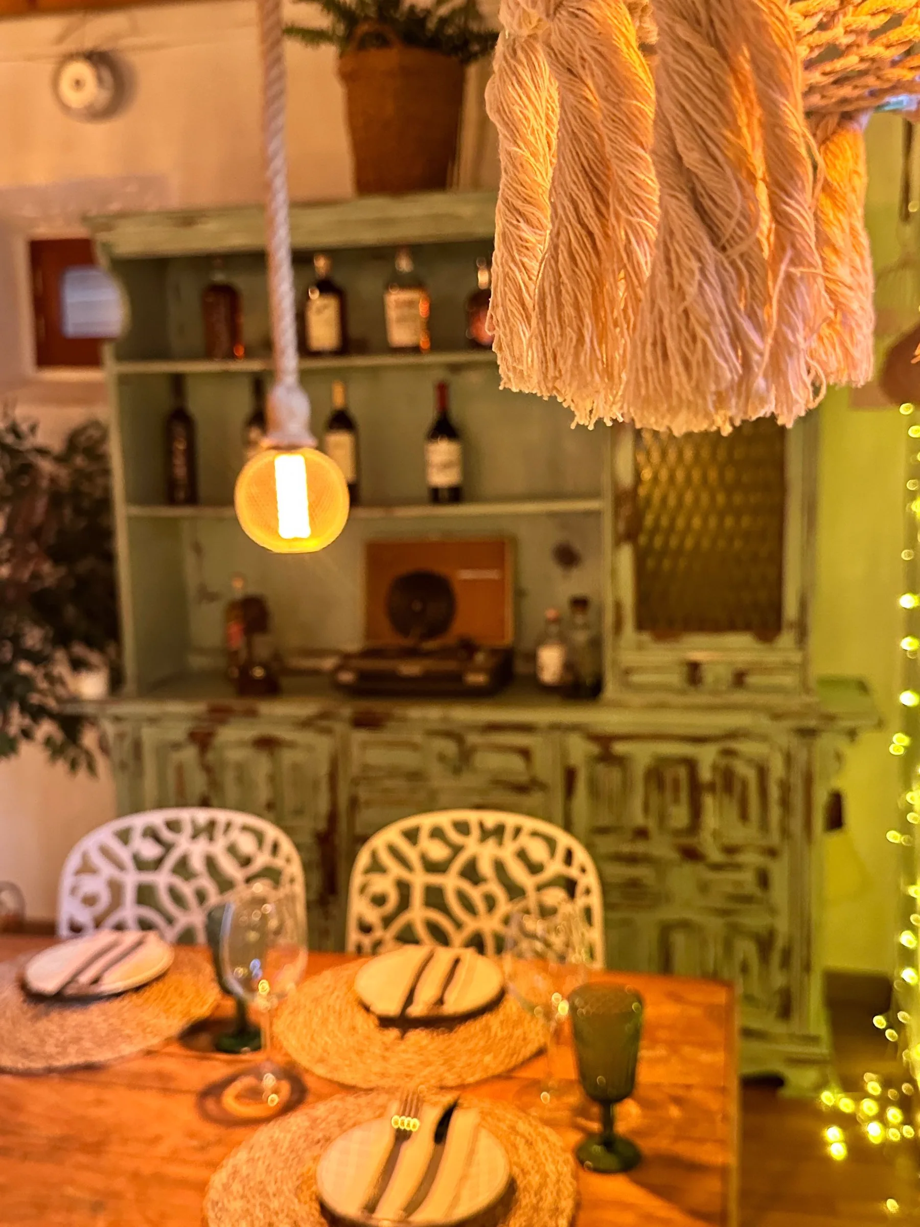 Mesa de comedor vestida con platos, copas y cubertería